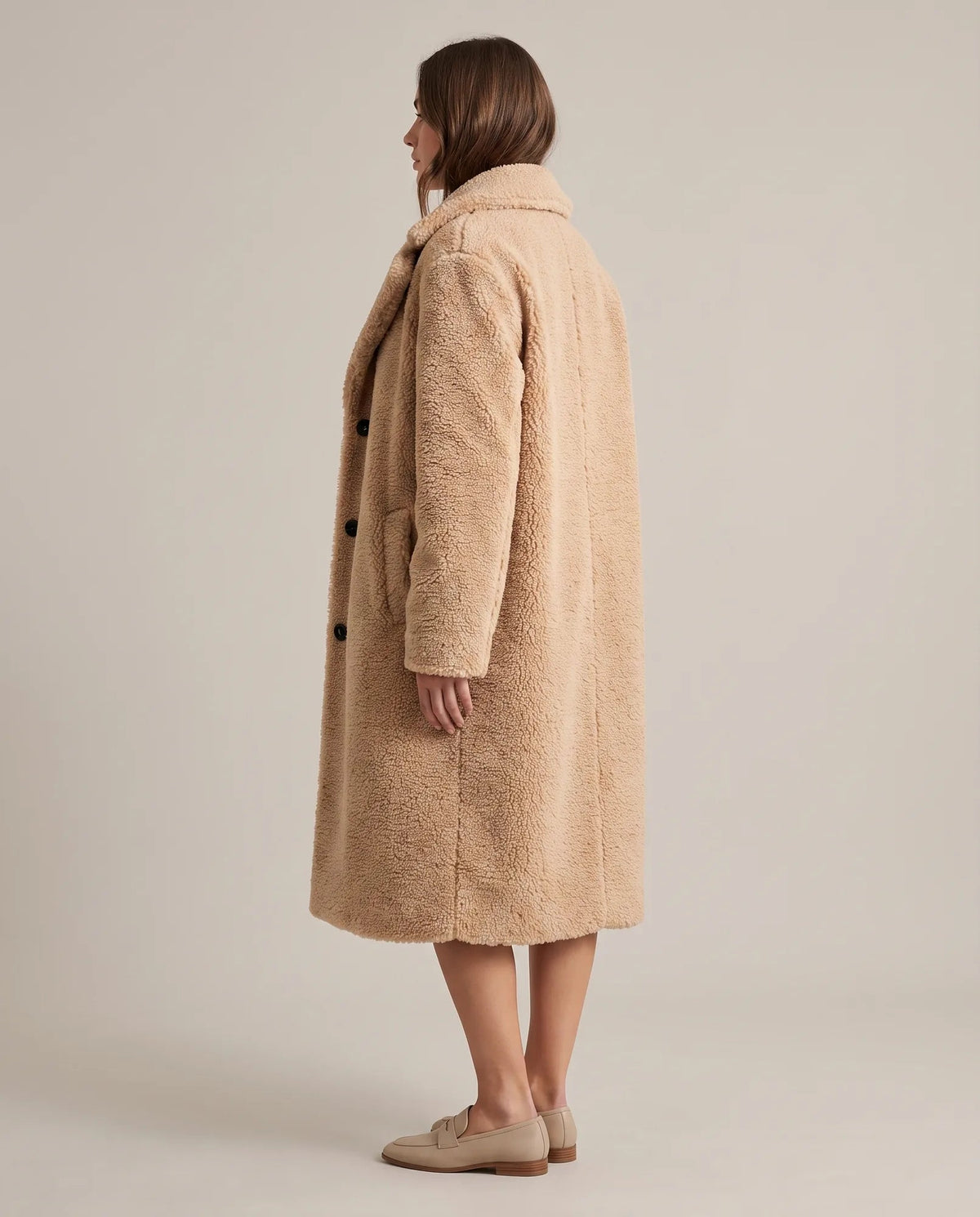 Angled view of khaki teddy coat showing long sleeves and longline silhouette