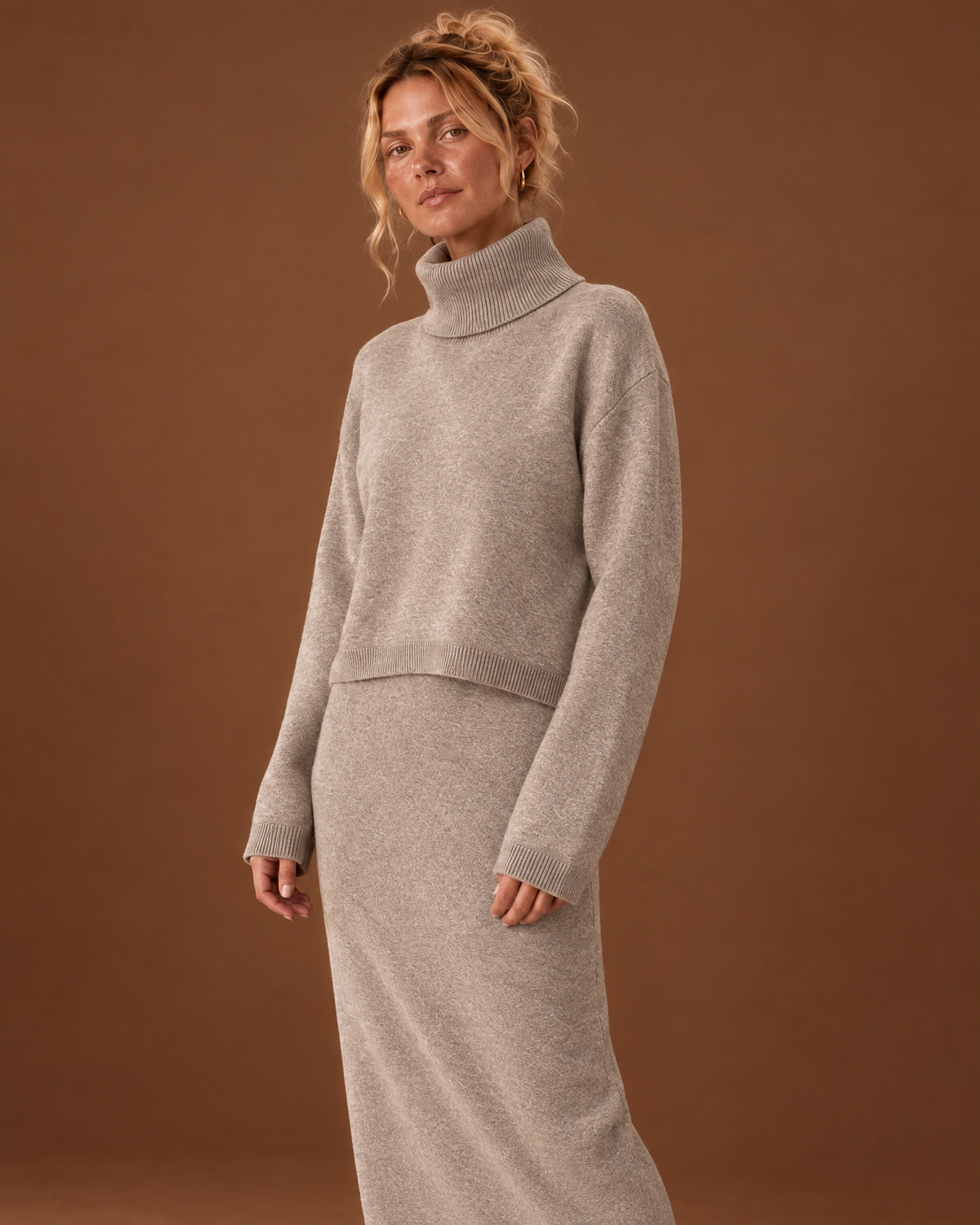 Closer view of the beige knit set showing the folded turtleneck, cropped sweater hem and matching dress