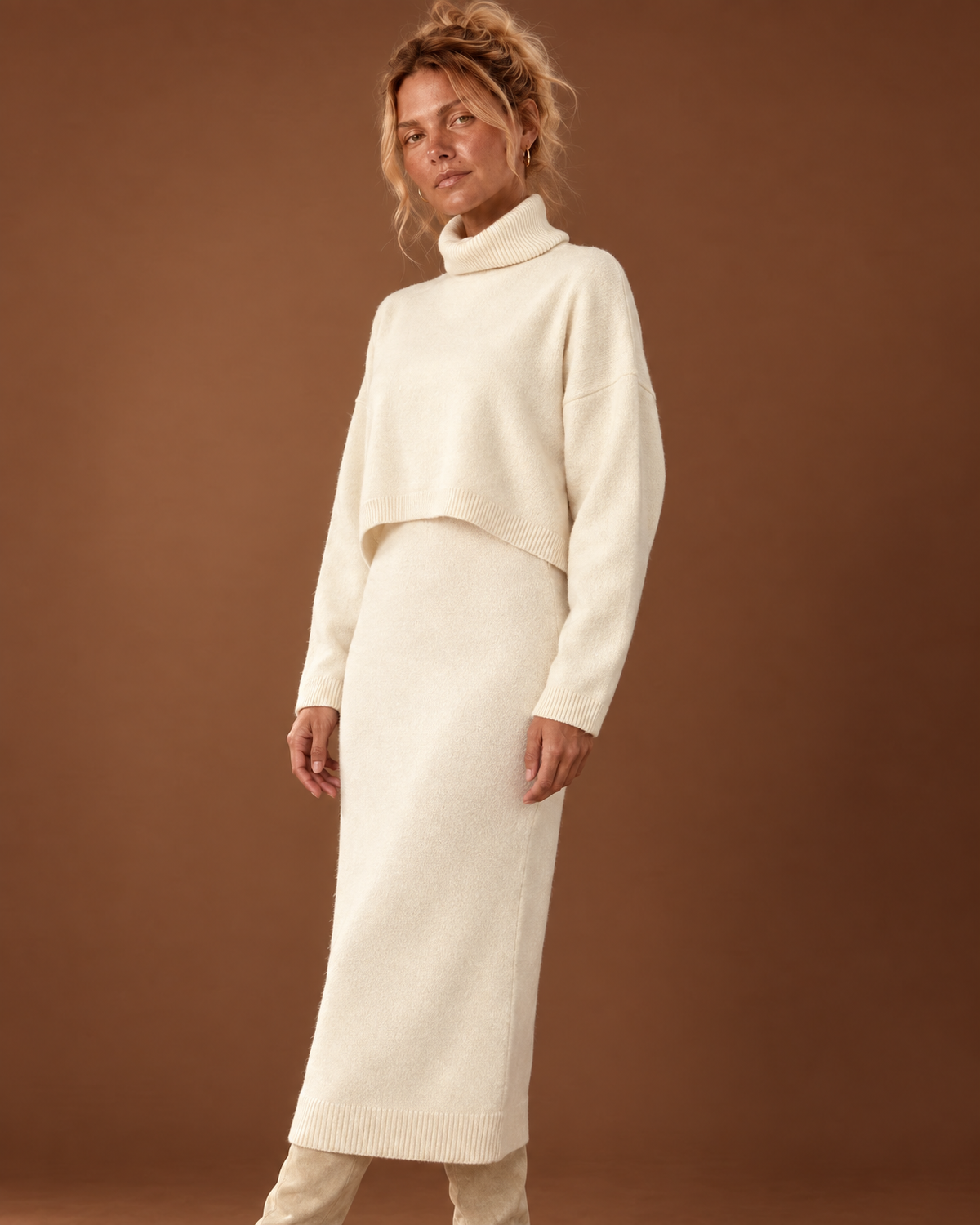 Closer view of the cream knit set showing the folded turtleneck, cropped sweater hem and matching dress