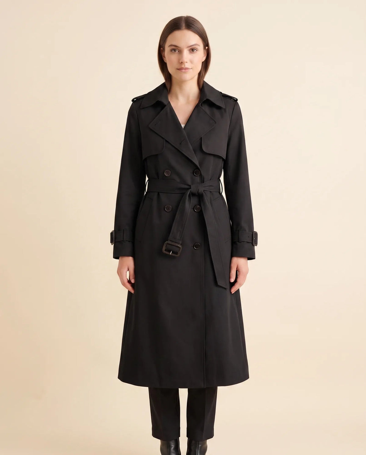 Women's black double-breasted longline trench coat with tied waist belt and notched collar, front view