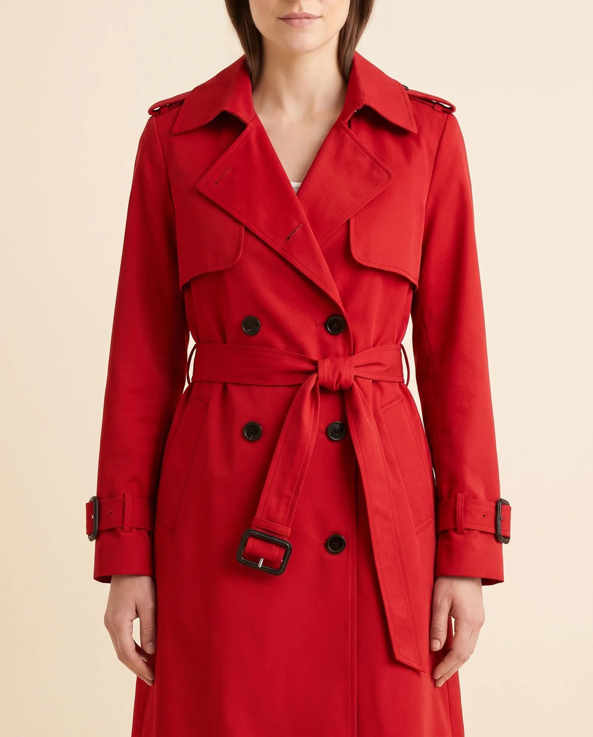 Close-up of red trench coat showing notched lapels, double-breasted buttons and waist belt