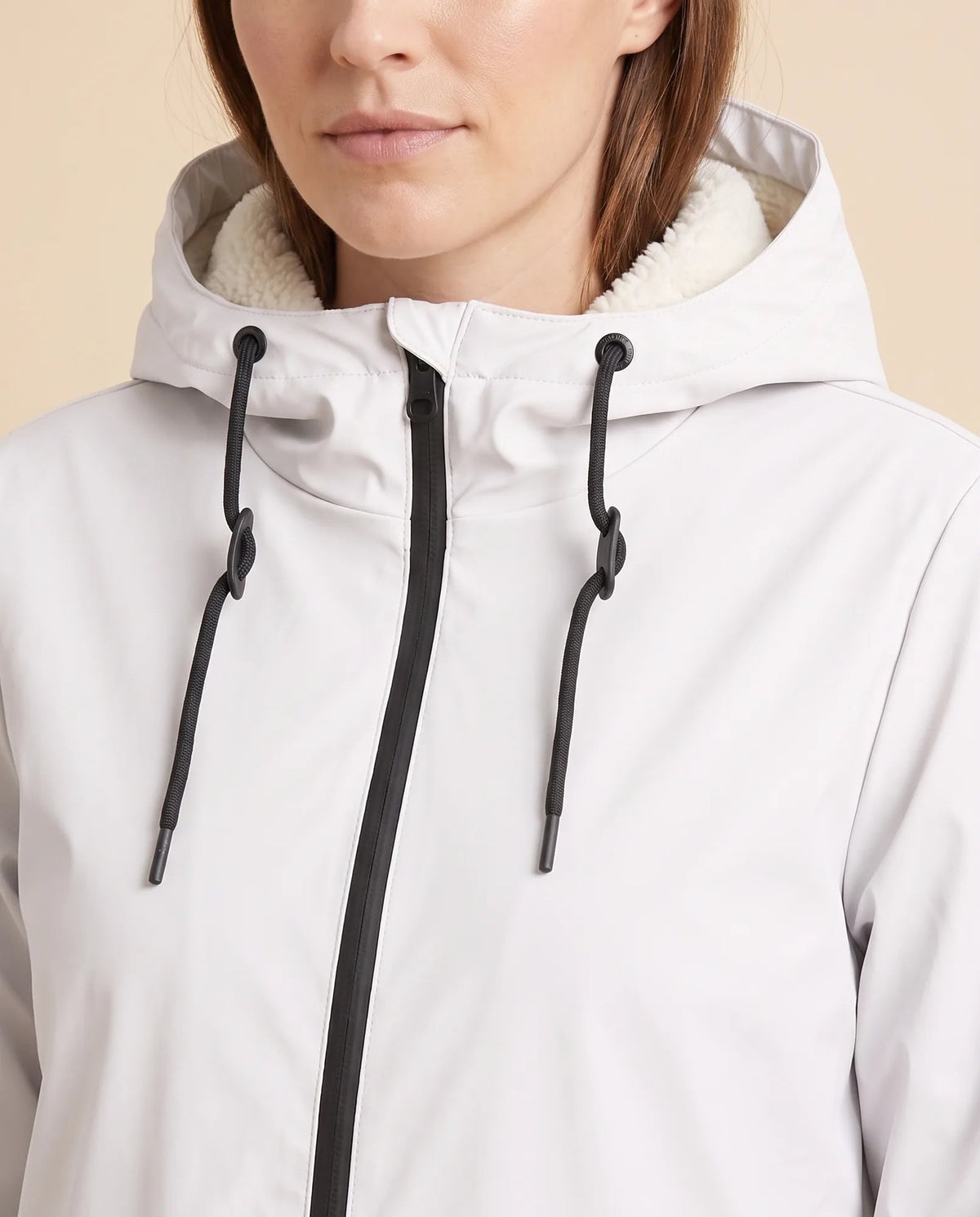 Women's lined hooded coat in white – close-up of the drawcord hood and zip front