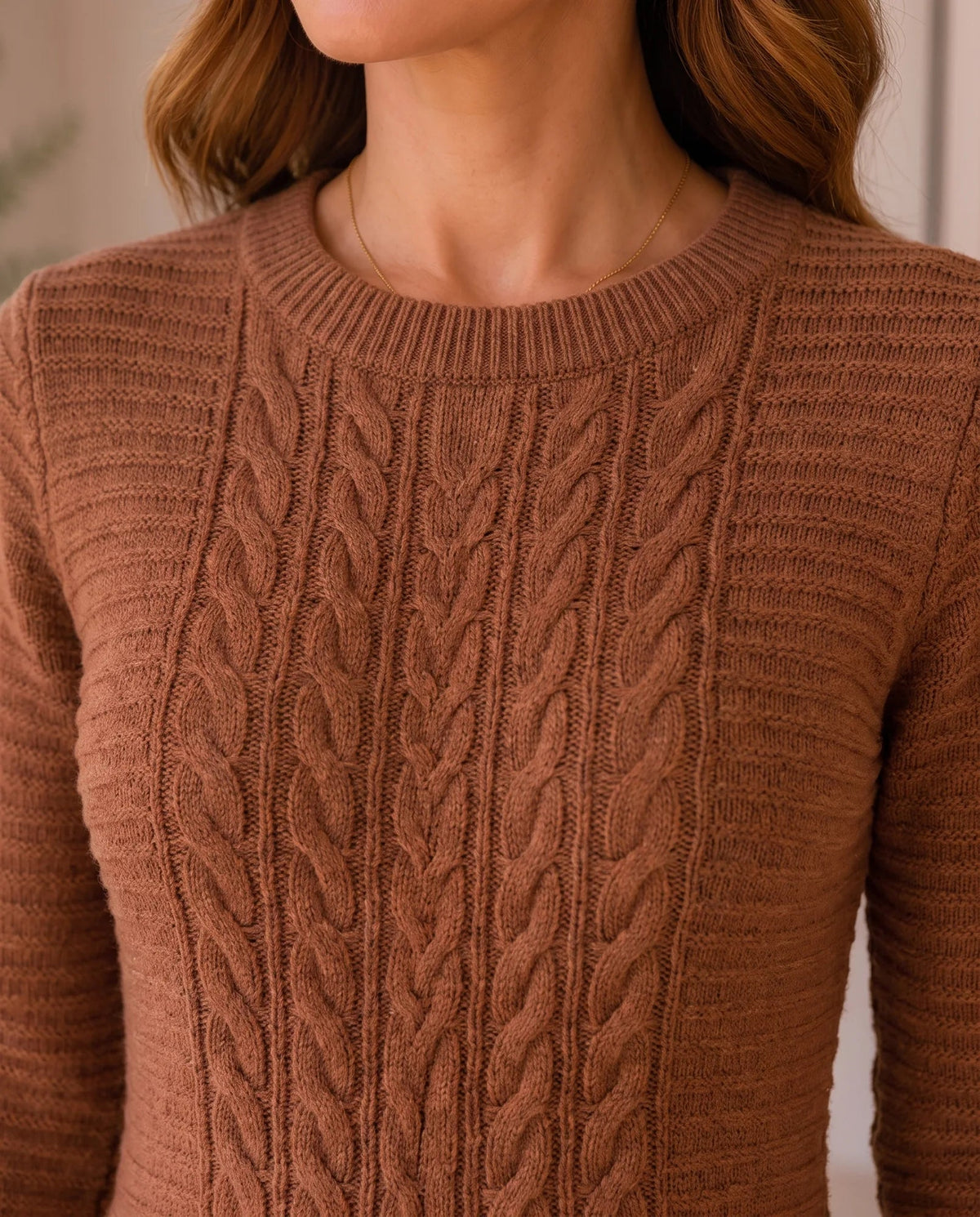 Close-up of the brown sweater dress showing the ribbed crew neckline and braided cable knit