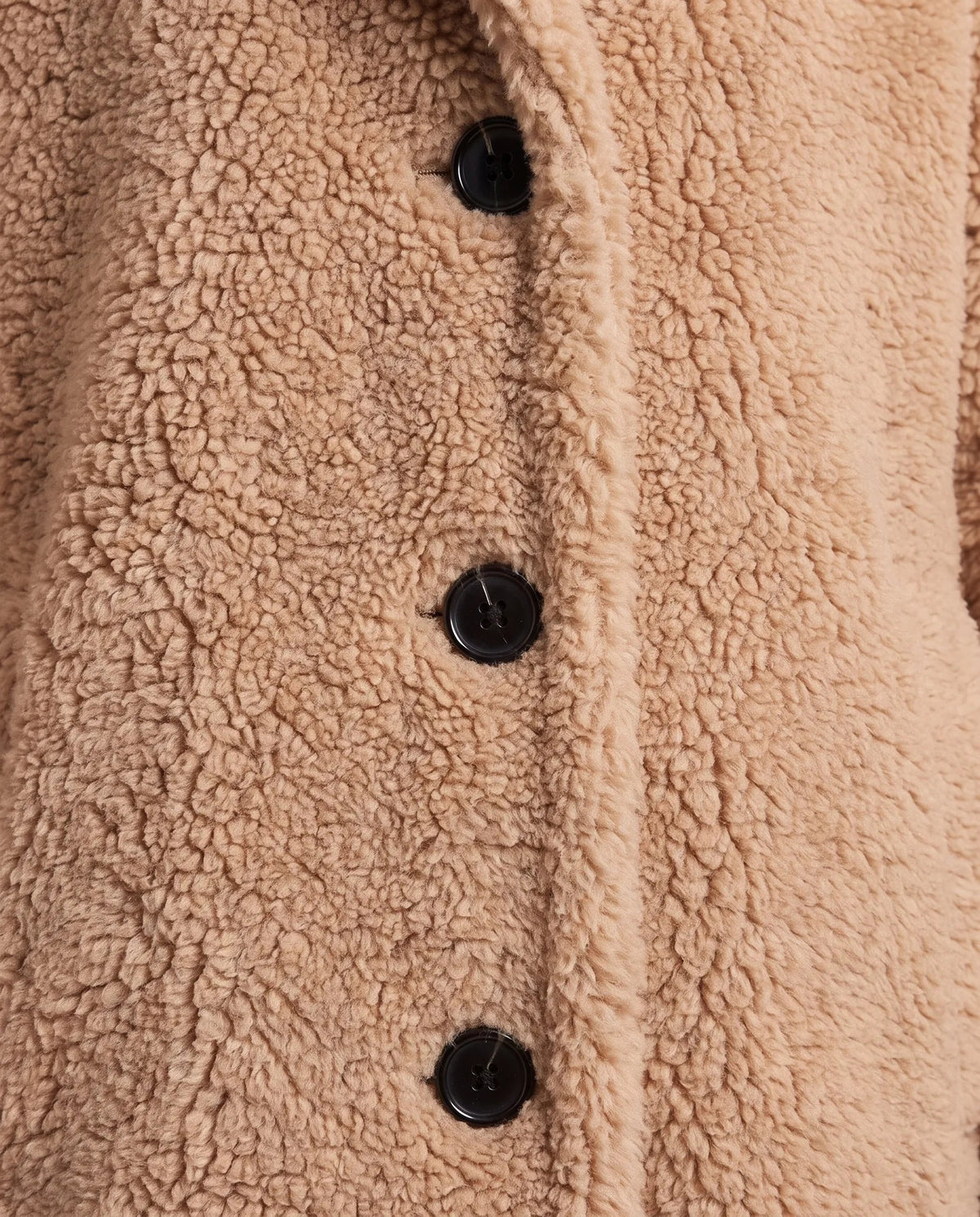 Close-up of khaki teddy fleece coat showing textured fabric and button fastening