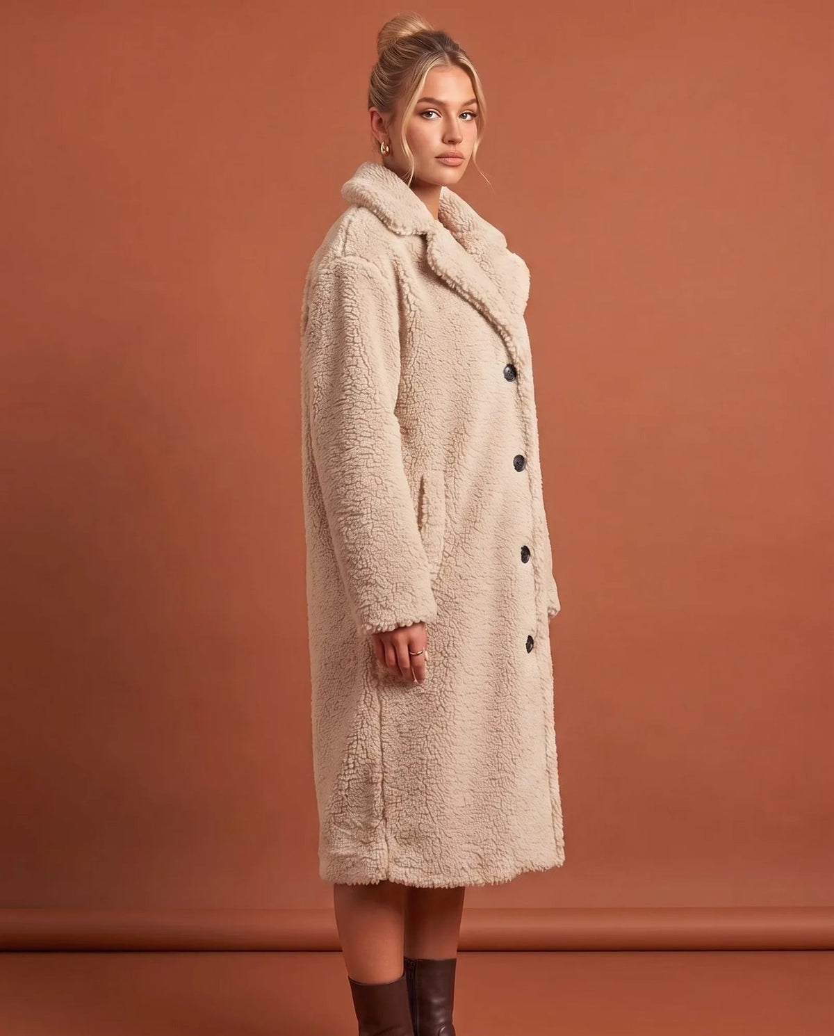 Angled view of white teddy coat showing long sleeves and longline silhouette