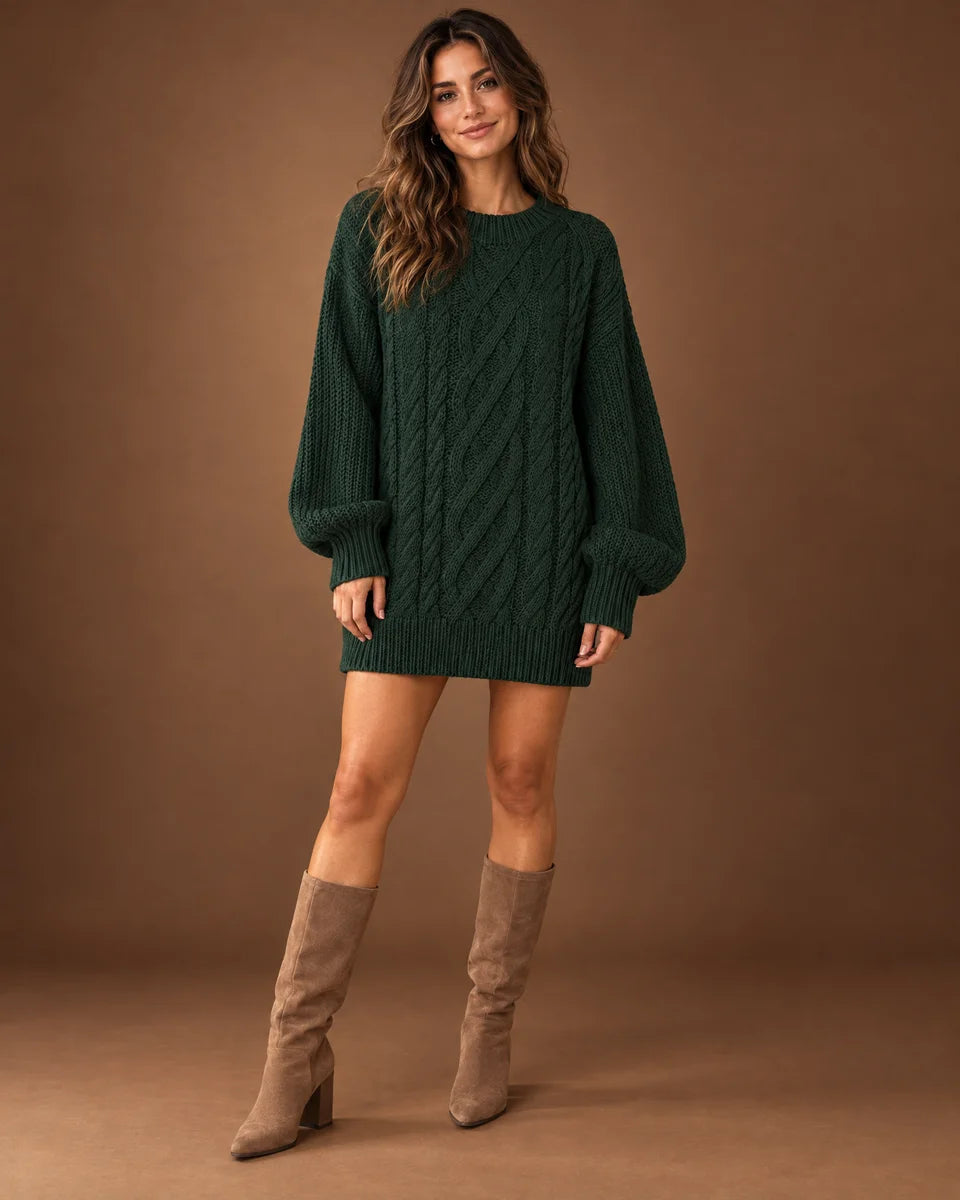 Women's dark green oversized cable knit sweater dress with a crew neck and long sleeves, studio front view