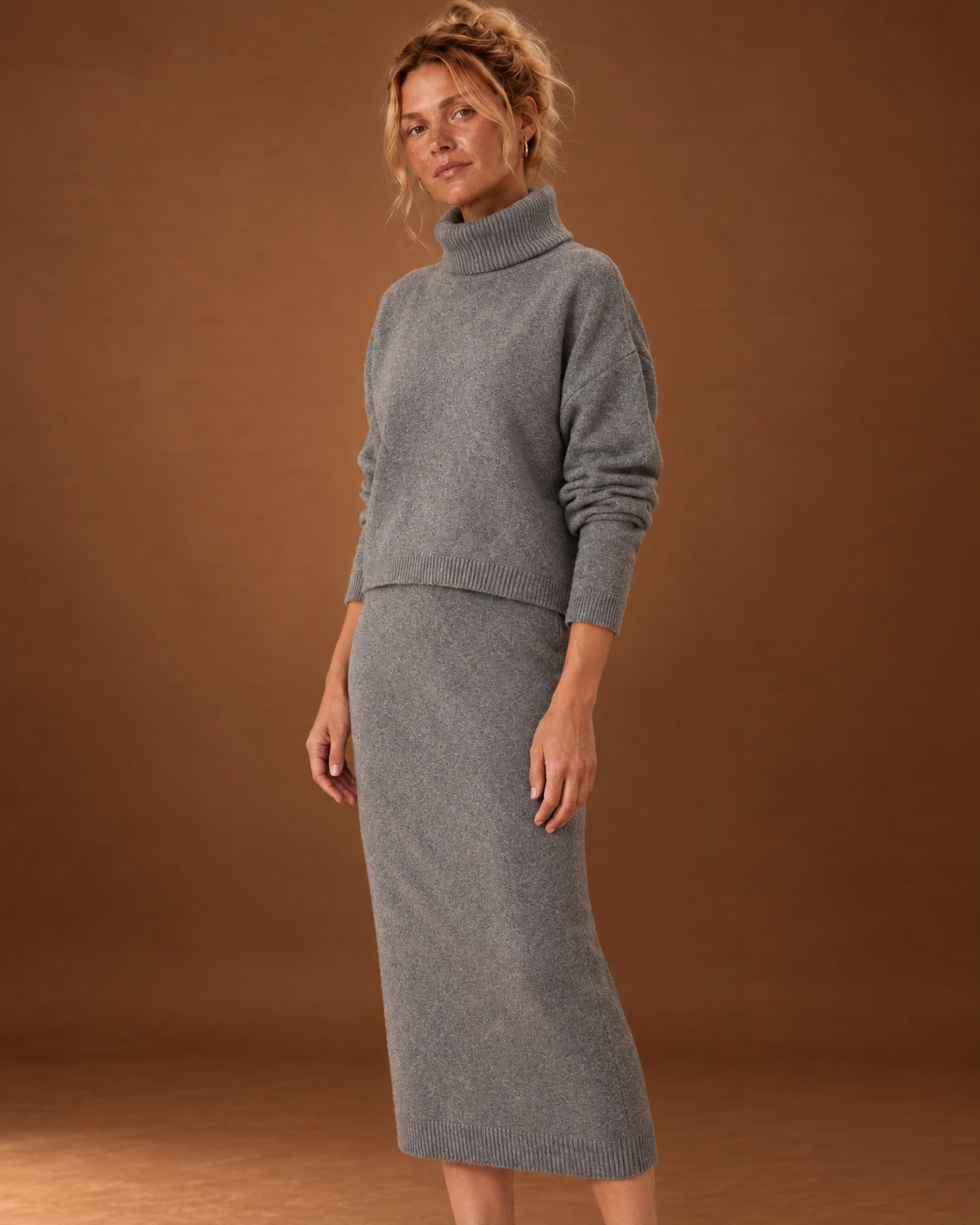 Closer view of the grey knit set showing the folded turtleneck, cropped sweater hem and matching dress