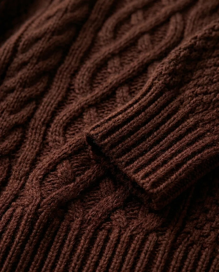 Close-up of the chocolate brown cable knit texture and ribbed sleeve cuff