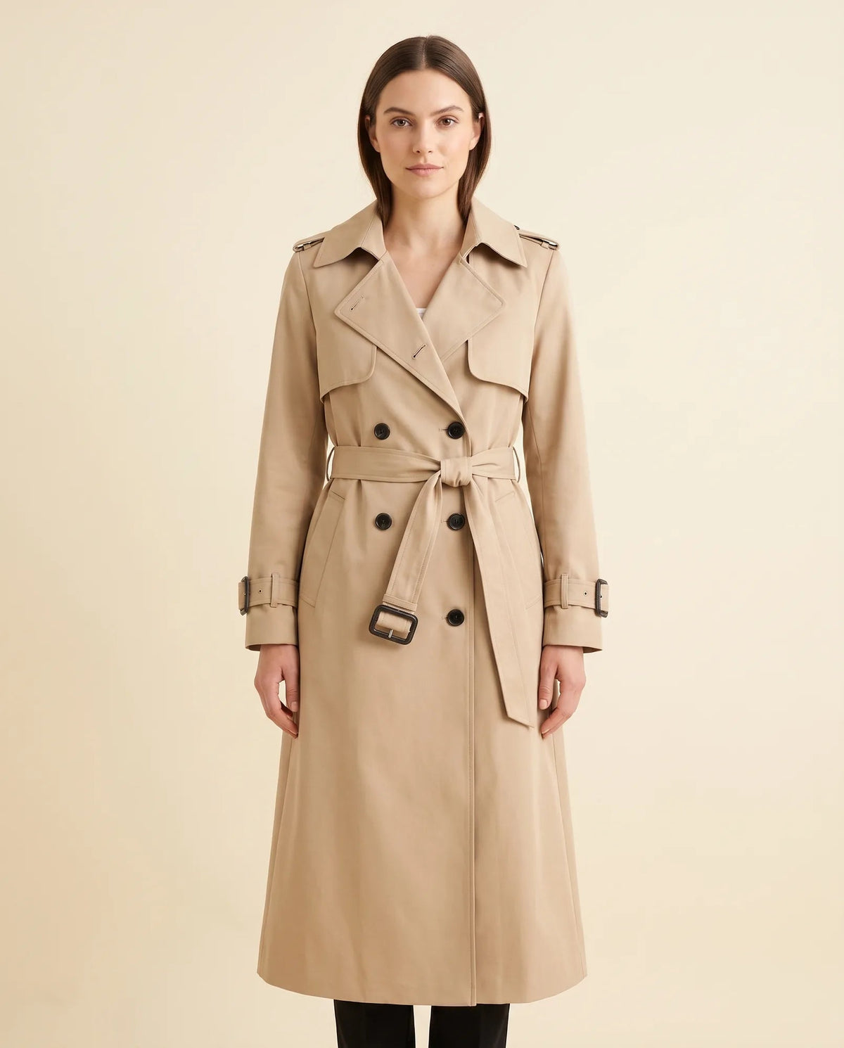 Women's beige double-breasted longline trench coat with tied waist belt and notched collar, front view