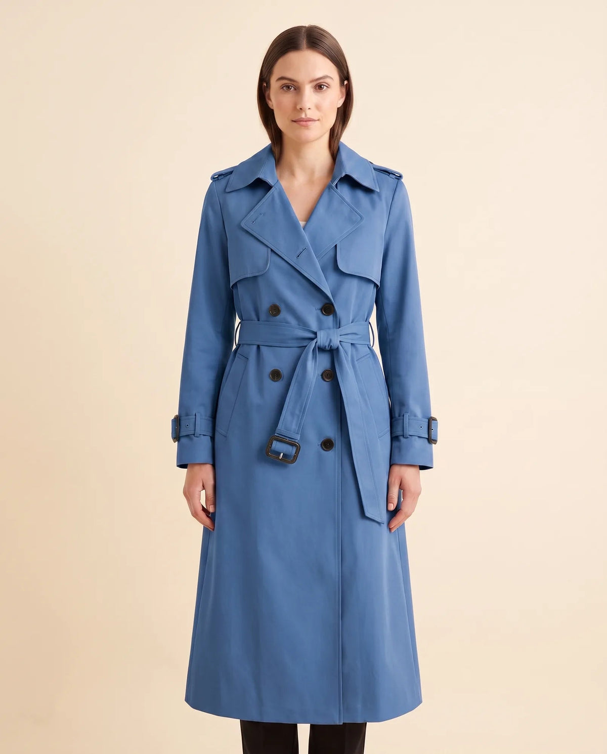 Women's blue double-breasted longline trench coat with tied waist belt and notched collar, front view