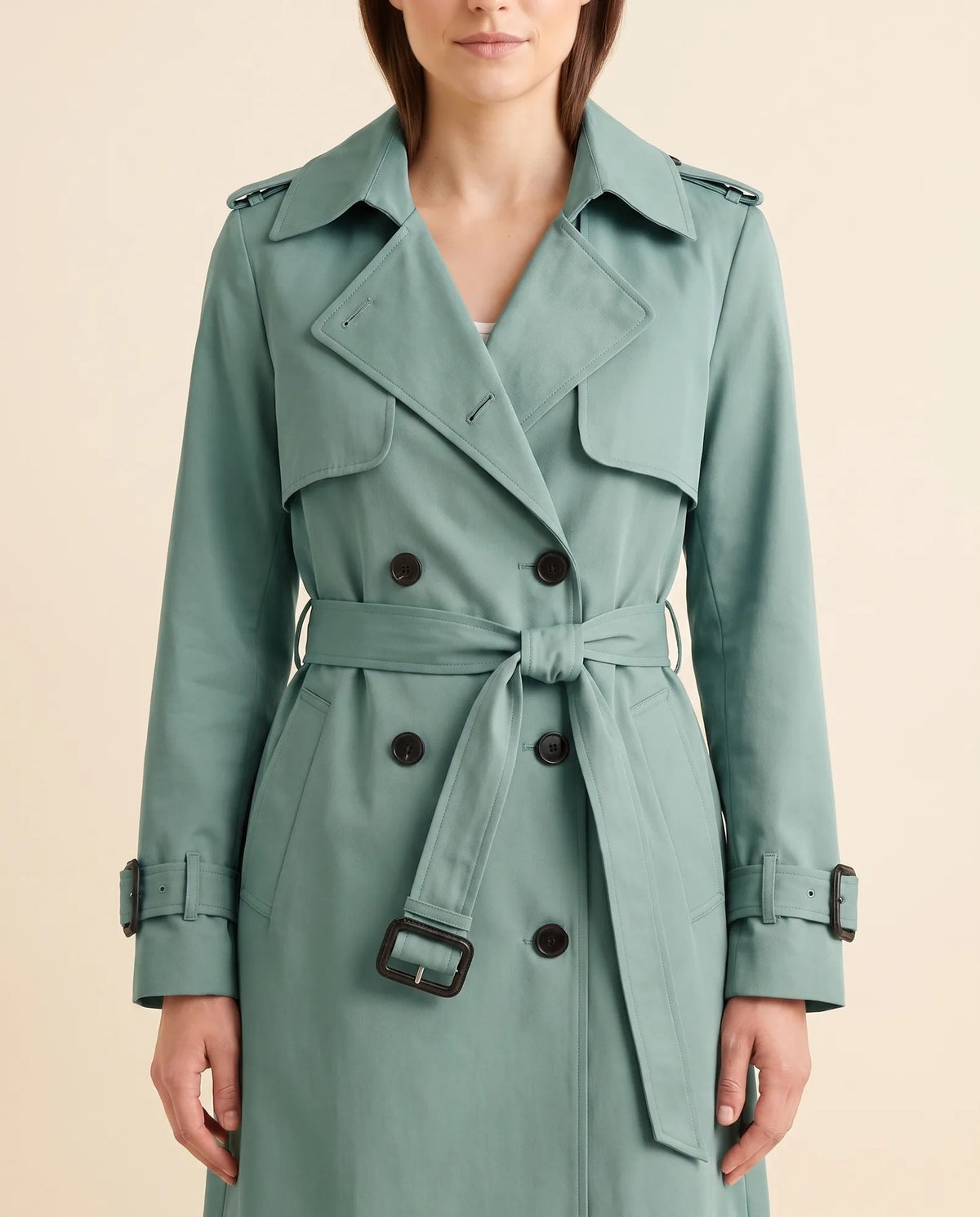 Close-up of green trench coat showing notched lapels, double-breasted buttons and waist belt