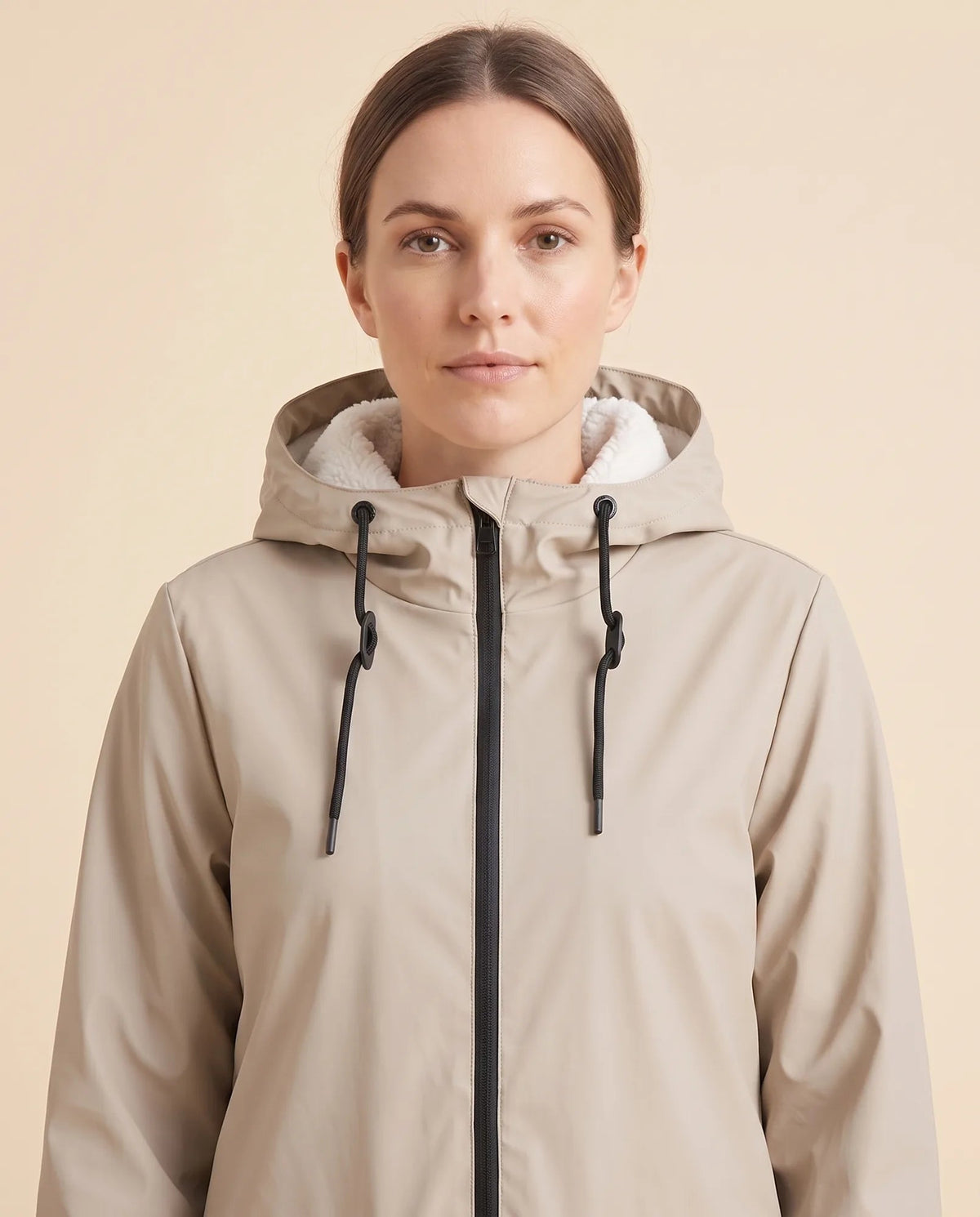 Women's lined hooded coat in beige – close-up of the drawcord hood and zip front